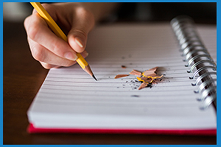 writing with pencil in a notebook, with pencil shavings near