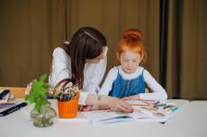 adult helping child with reading