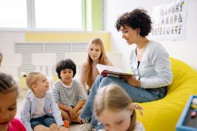 teacher reading to children in bright classroom